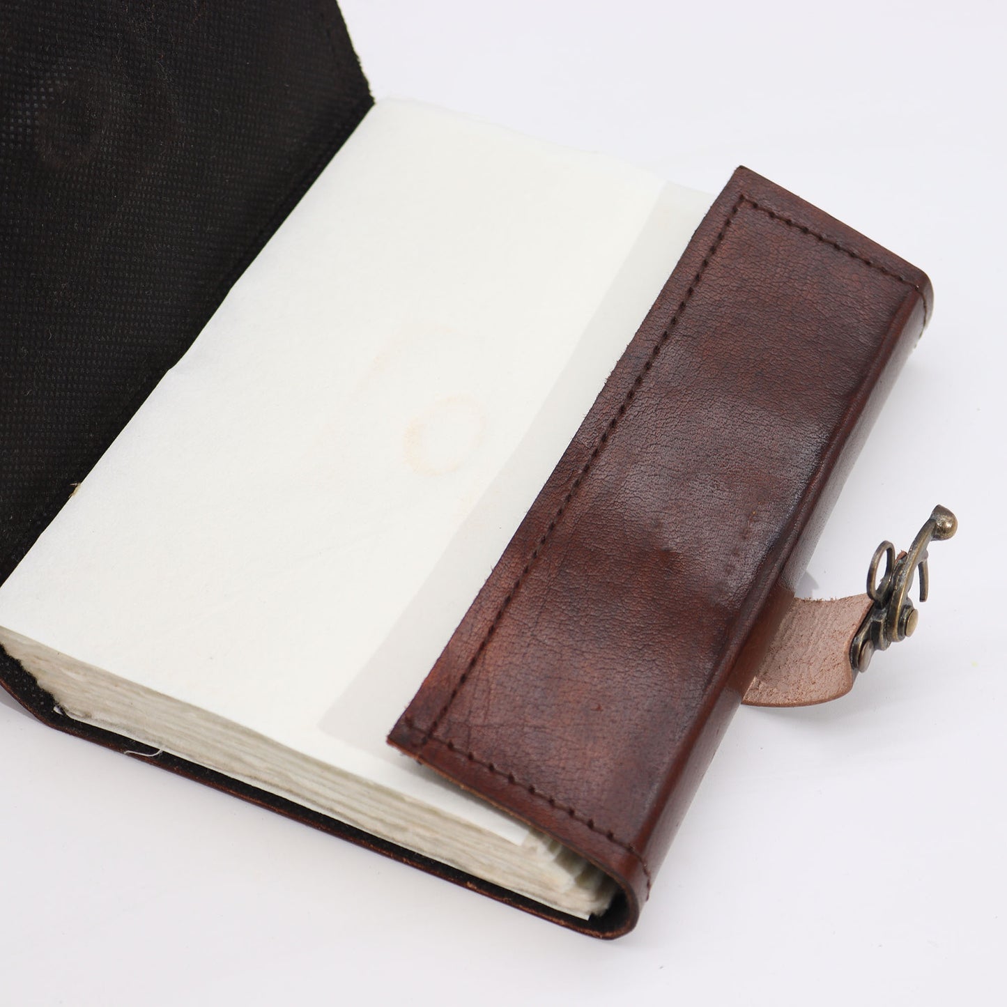 Carnet de notes marron foncé avec bords usés et motif « mauvais œil »